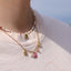 Collier Daisy avec médaillon fleur rose, perle d’eau douce et pierre de soleil porté au cou