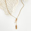 Collier doré en acier inoxydable avec pendentif “Amour” et perles naturelles.